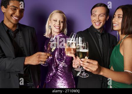 Fête de Noël, groupe d'amis multiethniques heureux en tenue festive clinking verres à champagne Banque D'Images