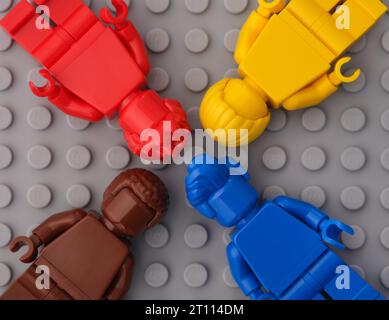 Tambov, Fédération de Russie - 01 octobre 2023 quatre figurines Lego monochromes - rouge, jaune, bleu et marron sur fond gris. Banque D'Images