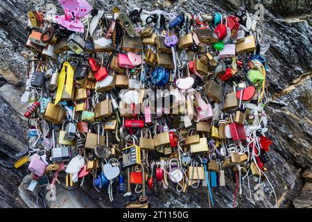 groupe de cadenas d'amour multicolores fixés à des fils sur une paroi rocheuse en suisse Banque D'Images