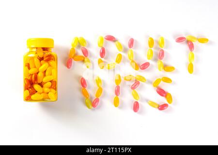 Vitamines Gummy et supplément pour adultes. La femme mange des micro-éléments de bonbons multivitaminés de gelée sucrée à partir de bouteilles de pilules transparentes, de médicaments modernes et Banque D'Images