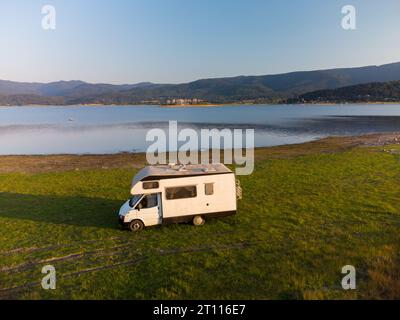 Vue aérienne de dessus d'un camping-car garé sur une plage, paysage de chaîne de montagnes Banque D'Images