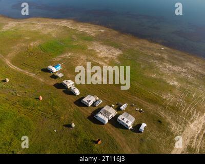 Vue aérienne de dessus d'une fourgonnette de camping garée sur une plage, paysage de chaîne de montagnes Banque D'Images