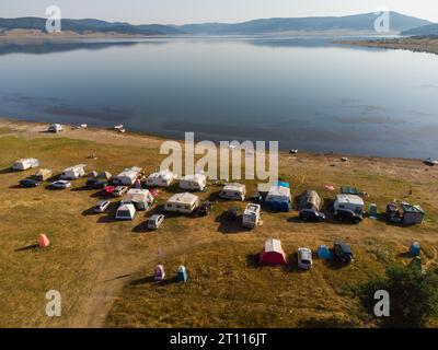 Vue aérienne de dessus d'une fourgonnette de camping garée sur une plage, paysage de chaîne de montagnes Banque D'Images