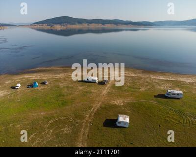 Vue aérienne de dessus d'une fourgonnette de camping garée sur une plage, paysage de chaîne de montagnes Banque D'Images