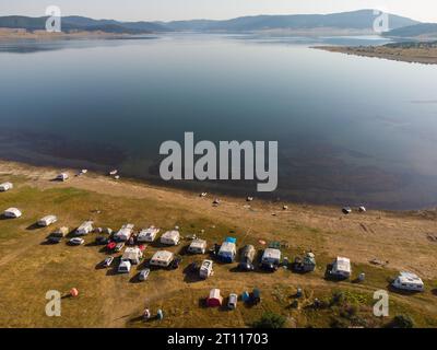 Vue aérienne de dessus d'une fourgonnette de camping garée sur une plage, paysage de chaîne de montagnes Banque D'Images