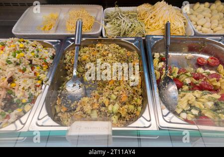 Pâtes fraîches, riz et salade douce, tomate, coleslaw, etc., à vendre au poids dans l'armoire d'aliments réfrigérés / allée de réfrigérateur d'aliments dans un mini supermarché. (135) Banque D'Images