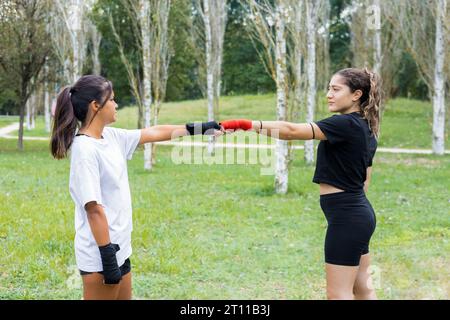 Deux jeunes boxeuses féminines s'entraînant en plein air. Entraînement de boxe et de poinçonnage. Banque D'Images
