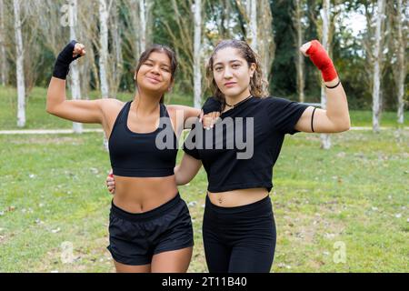 Portrait de deux jeunes boxeuses multiethniques dans un parc de la ville. Entraînement sportif en plein air. Banque D'Images