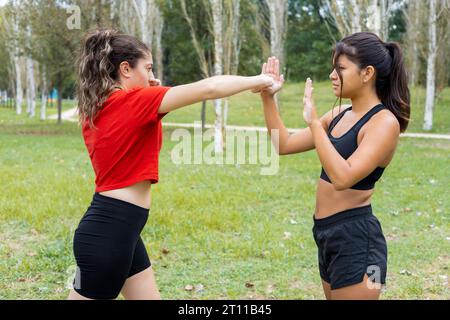 Deux jeunes boxeuses féminines s'entraînant en plein air. Entraînement de boxe et de poinçonnage. Banque D'Images