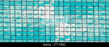 Mosaïque abstraite de carrés dans les tons bleus et blancs. Le ciel bleu avec des nuages blancs se reflète dans le miroir. Intersection de rayures créant un Banque D'Images