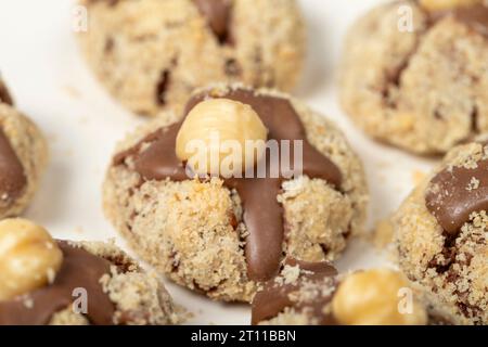 Biscuits aux noisettes. Biscuits au chocolat et aux noisettes sur fond en bois blanc. produits de pâtisserie. Gros plan Banque D'Images