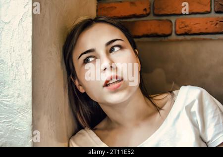 Gros plan portrait de style de vie de jeune femme contre le mur de briques Banque D'Images