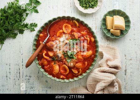 Soupe. Soupe de tomates fraîches avec boulettes de viande, pâtes, légumes et persil dans un bol rustique vert sur fond de bois. Cuisine italienne traditionnelle. Sain Banque D'Images