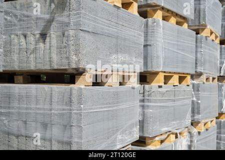 Palettes avec dalles de pavage grises empilées mise au point sélective pile de dalles de pavage dans la réparation de route d'entrepôt ou l'espace de vente de carreaux finis pour le texte Banque D'Images