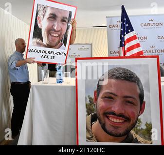 Tel Aviv, Israël. 10 octobre 2023. Des hommes accrochent des photos des Israéliens américains Sagui Dekel-Chen, 35 ans, et Itay Chen, 19 ans, portés disparus et soupçonnés d’être retenus en otage par le Hamas à Gaza, exposées lors d’une conférence de presse à tel Aviv, Israël, le mardi 10 octobre 2023. Photo de Debbie Hill/ crédit : UPI/Alamy Live News Banque D'Images