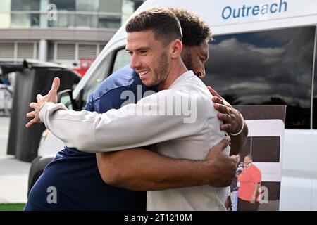 Foxborough, États-Unis. 10 octobre 2023. L'Allemand Robin Gosens (à l'avant) embrasse Tully Banta-Cain, ancien linebacker de football américain pour les Patriots de la Nouvelle-Angleterre, lors d'un événement communautaire. Crédit : Federico Gambarini/dpa/Alamy Live News Banque D'Images