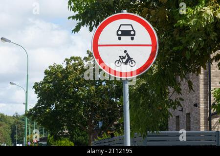 Un panneau routier interdisant la circulation des voitures et des motocyclettes sur ce tronçon de la route. Gros plan. Banque D'Images