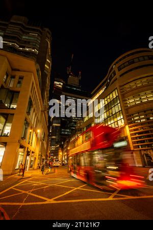 Londres, Royaume-Uni : bus rouge de Londres avec flou de mouvement sur Gracechurch Street dans la ville de Londres la nuit. Un gratte-ciel Leadenhall en construction derrière. Banque D'Images