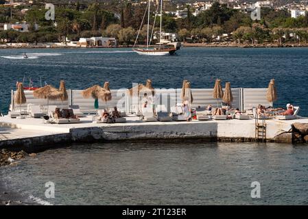 Elounda, Crète, Grèce, Europe. 29.09.2023. Les vacanciers prennent un bain de soleil sur une jetée étendue sur la mer de Mirabella, Crète orientale. Banque D'Images