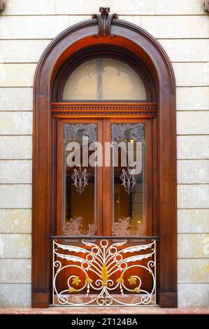 Fenêtre extérieure cintrée dans la façade du bâtiment. La structure est faite de bois dur et de verre. Une petite balustrade de décoration est au premier plan. Banque D'Images