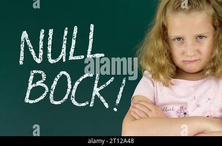 Écolier devant un tableau noir avec le mot allemand : NULL Bock (zero enthousiasme) Banque D'Images