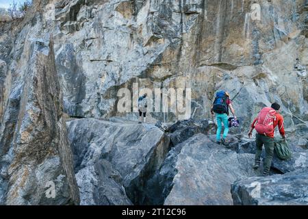 Grimpeurs se préparant pour l'ascension. Trois hommes femmes marchant sur les rochers. Sports extrêmes en plein air. Banque D'Images