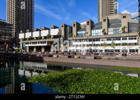 Une vue sur le lac en face du Barbican Centre, avec les blocs d'appartements Cromwell Tower en arrière-plan. Le Barbican Centre est un centre renommé Banque D'Images