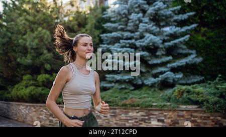 Belle femme diabétique courant dans la ville. Jeune femme portant la pompe à insuline pendant l'exercice. Concept d'exercice et diabète. Banque D'Images