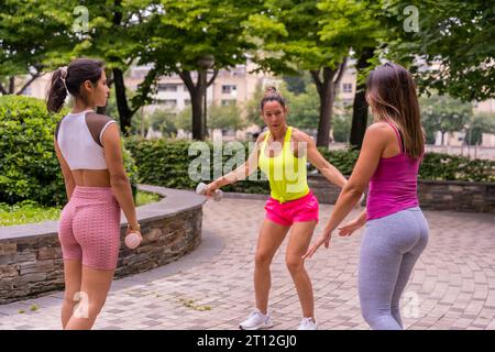 Fille Latina faisant du sport dans un parc dans la ville, mode de vie une vie saine, élèves enseignants s'exerçant avec des poids Banque D'Images