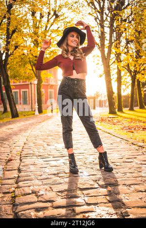 Fille caucasienne avec chapeau dans une forêt marchant en automne Banque D'Images