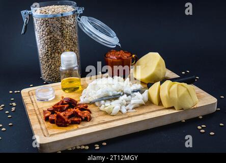 Ingrédients tomate, oignon, chorizo et pommes de terre. Recette maison d'un plat de lentilles espagnol Banque D'Images