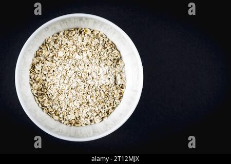 Recette de flocons d'avoine avec noix, pruneaux, cannelle et sucre. Flocons d'avoine dans une tasse blanche avec espace copier-coller Banque D'Images