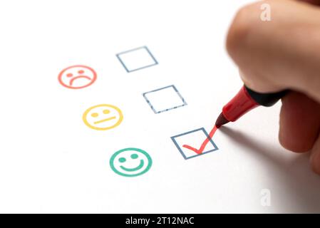 Questionnaire de satisfaction client et concept d'enquête avec un visage souriant coché. Banque D'Images