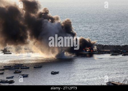 Gaza. 10 octobre 2023. De la fumée s’accumule après une frappe israélienne sur le port de la ville de Gaza, le 10 octobre 2023. Au moins 900 Palestiniens ont été tués dans les attaques israéliennes en cours sur la bande de Gaza, selon le ministère de la Santé à Gaza mardi. Pendant ce temps, au moins 1 008 personnes ont été tuées en Israël depuis que le Hamas a lancé une attaque surprise sur le pays samedi, a rapporté mardi le journal d'État Kan TV. Crédit : Rizek Abdeljawad/Xinhua/Alamy Live News Banque D'Images