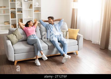 Couple indien aimant, reposant les mains derrière la tête et souriant les uns aux autres Banque D'Images