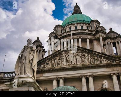 La statue de la reine Victoria devant l'hôtel de ville de Belfast. Le dôme en cuivre vert couronné de lanterne de 173 pi (53 m) apparaît en arrière-plan. Banque D'Images