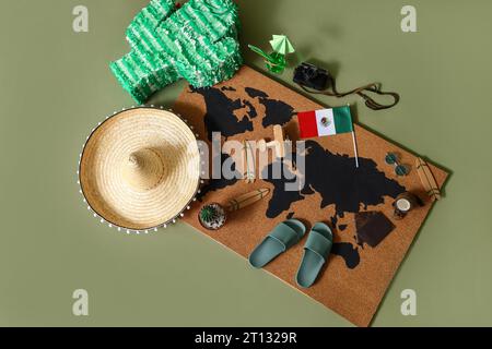 Pinata avec carte, drapeau mexicain et accessoires de plage sur fond vert. Concept de voyage Banque D'Images