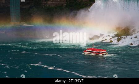 Gros plan du bateau de croisière Hornblower voyageant sous un arc-en-ciel en face des chutes américaines de Niagara Falls. Banque D'Images