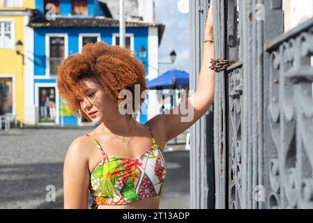 Mature et belle rousse souriante femme dans la robe colorée debout par une balustrade en fer. Personne heureuse voyageant. Banque D'Images