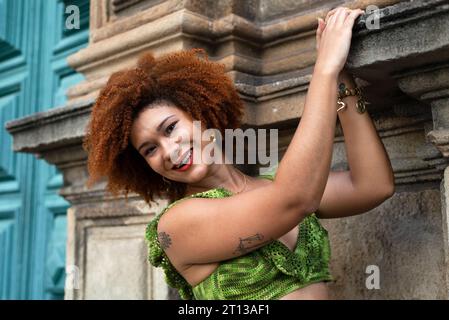 Portrait rapproché d'une belle femme aux cheveux roux appuyé contre un mur dans une église. Personne heureuse voyageant. Banque D'Images