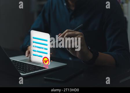 L'homme d'affaires utilise la liste de contrôle d'ordinateur portable note de satisfaction du client sur un service de document numérique assurance qualité, écran virtuel de document de certification. Banque D'Images