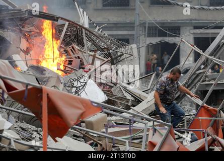 Gaza, Palestine. 10 octobre 2023. Un palestinien inspecte un bâtiment endommagé à la suite des frappes israéliennes, suite à une attaque surprise du Hamas dans la ville de Gaza. Israël a déclaré qu'il avait repris les zones frontalières de Gaza au Hamas alors que le nombre de morts de la guerre dépassait les 3 000 le 10 octobre, quatrième jour de combats exténuants depuis que les islamistes avaient lancé une attaque surprise. Crédit : SOPA Images Limited/Alamy Live News Banque D'Images