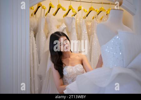 La mariée essaie sa robe au studio. Cérémonie de mariage et concept de style de vie. Banque D'Images