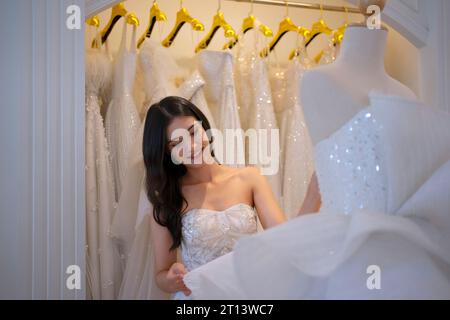 La mariée essaie sa robe au studio. Cérémonie de mariage et concept de style de vie. Banque D'Images