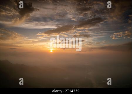 Le soleil se lève derrière les montagnes. Il illumine les villages de la vallée. Le paysage le long de l'autoroute Alishan. Comté de Chiayi, Taïwan. Banque D'Images