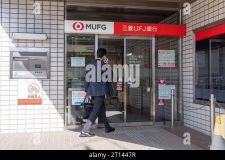 Tokyo, Japon. 11 octobre 2023. Un homme entre dans un bureau de la banque MUFG à Tokyo, Japon, le 11 octobre 2023. Le pépin du système subi par le réseau japonais de compensation des paiements n'a montré aucun signe de reprise, avec 11 banques affectées et des millions de transactions perturbées, a déclaré l'opérateur mercredi. Crédit : Zhang Xiaoyu/Xinhua/Alamy Live News Banque D'Images