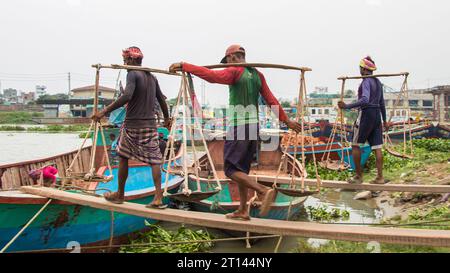 Les gens déchargent des briques du bateau, image capturée le 29 mai 2022, depuis Amen Bazar, au Bangladesh, où les travailleurs sont occupés à décharger des briques lourdes Banque D'Images