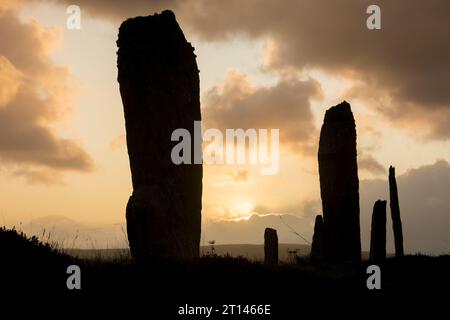 Le soleil se lève derrière les pierres debout néolithiques de l'anneau de Brodgar, Orcades, Royaume-Uni. Banque D'Images