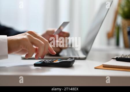 Photo recadrée de l'homme calculant les dépenses et la dette des cartes de crédit. Commerce électronique, planification financière et dépenses Banque D'Images