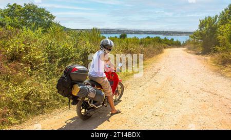 Un jeune homme va camper avec sa moto. Culture du camping sur les rives. Voyager en moto.la moto porte la clé de la liberté Banque D'Images